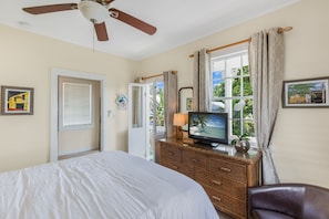 Relax in this inviting space with a large bed, TV, and ceiling fan.