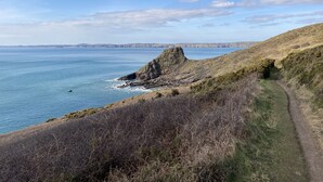 A coastal landscape with a rocky outcrop and a clear view of the sea. - Pembs Campervan VW T5 Travel and Stay in Style (Haverfordwest)