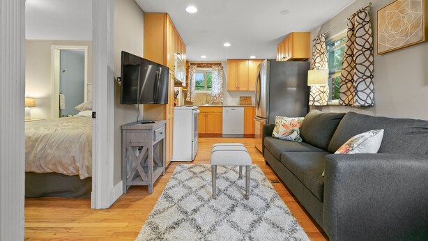 Ein modernes Apartment mit Wohnzimmer, Küchenzeile und Schlafzimmer.
