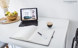 A laptop displaying an interior view of a room with a blue sofa, a coffee cup, and a bowl of fruit on a table. - Apartment 2 minutes walk from the main station with Netflix (Magdeburg)