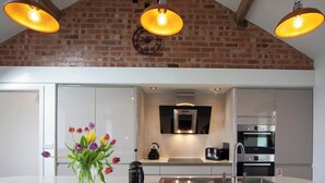 A modern kitchen with a brick wall, pendant lights, a kettle, and a coffee maker. - Hot Tub*,Fire, Super-king , Zip n Link beds.Views (PRESTON)