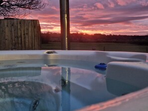A hot tub with a wooden fence and a sunset in the background. - Hot Tub*,Fire, Super-king , Zip n Link beds.Views (PRESTON)