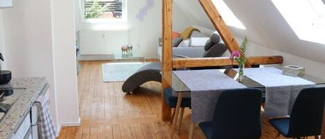 A cozy loft-style bedroom with a sloped ceiling, a wooden bed frame, and a skylight.