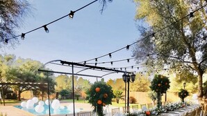 An outdoor dining area with tables set for a meal, surrounded by greenery and string lights. - Beautiful Finca Sa Canova Agroturismo in Campos (Campos)