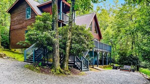 A wooden cabin with a balcony, surrounded by trees. - Modern Lodge | Hot Tub | EV Charger | Near Blue Ridge Pkwy (Boone)