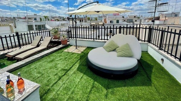 Relax on the rooftop with a comfortable bench and lush greenery.