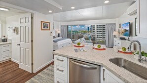 Cocina moderna con una isla grande, horno empotrado y vistas a la ciudad.