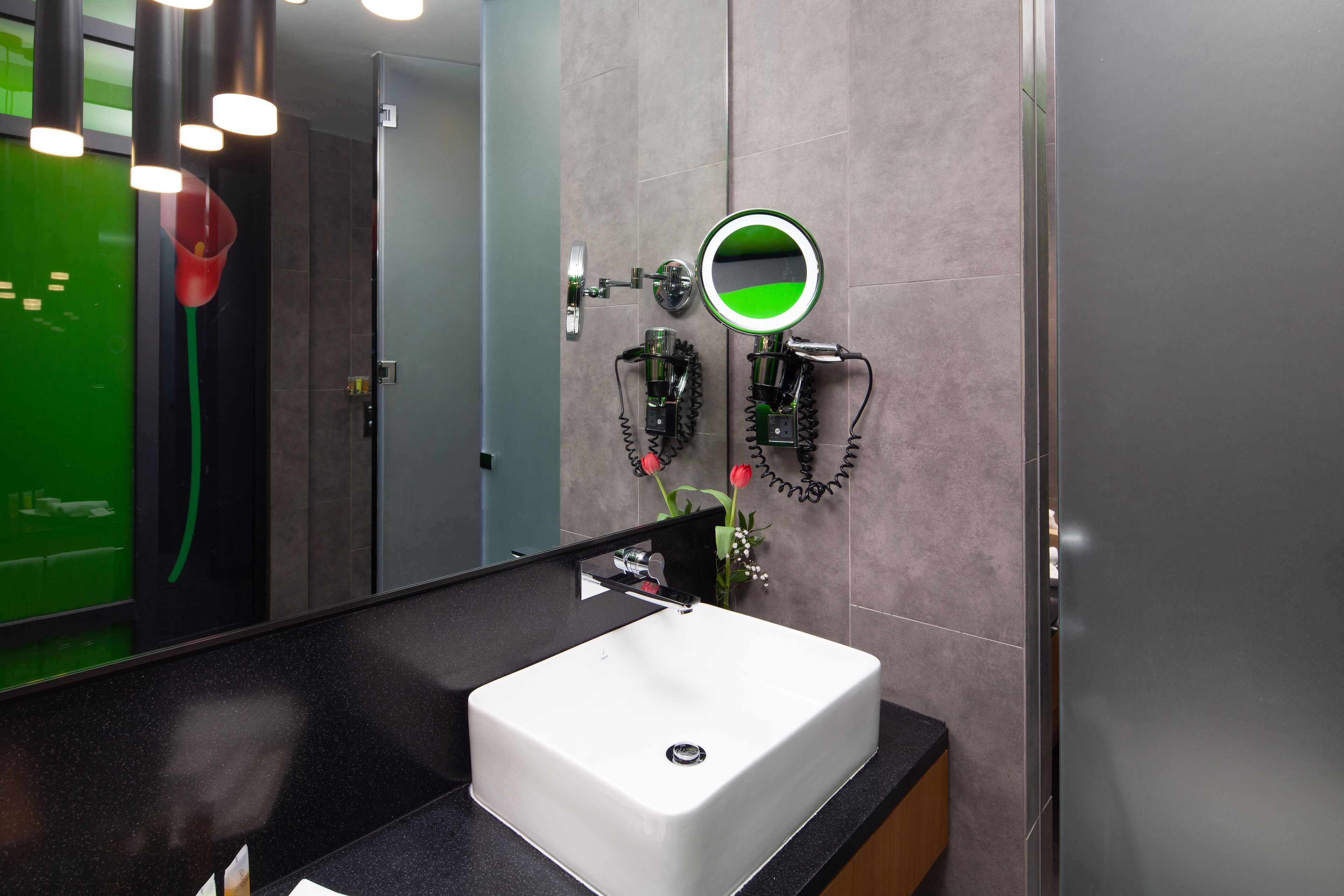 Een moderne badkamer met een witte wastafel, een spiegel en een handdoekrek.