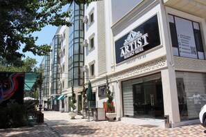 Un hôtel de style « Régence » doté d’une façade moderne, de grandes fenêtres et d’une rue pavée de briques.