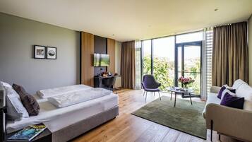 Ein modernes Hotelzimmer mit einem Bett, einem Schreibtisch, einem Sessel und einer Couch.