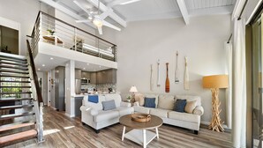 A spacious living area with a staircase, a kitchen, and a dining area.