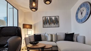 Ein modernes Wohnzimmer mit einer Couch, einem Couchtisch und einer Wanduhr.