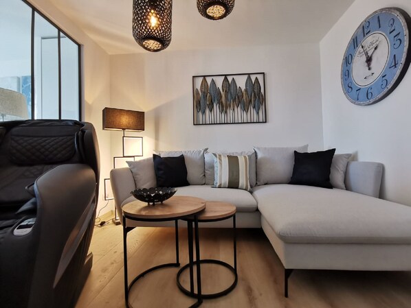 Una sala de estar moderna con un sofá, una mesa de centro y un reloj en la pared.