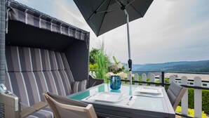 Ein Essbereich mit Tisch, Stühlen und Sonnenschirm.