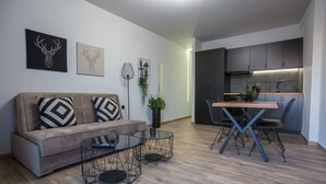 Una sala moderna con sofá, una mesa de centro y un comedor con sillas.