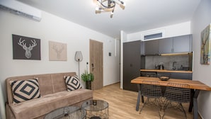 Un espacio de estar moderno con sofá, mesa de centro, mesa de comedor y sillas.