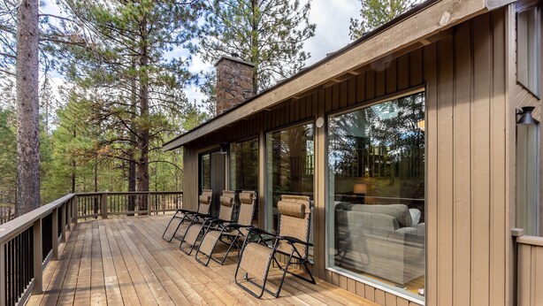 A wooden deck with outdoor seating and large windows. - Near SHARC, Hot Tub, Bikes, Dog-Friendly-LEIS03 (Sunriver)