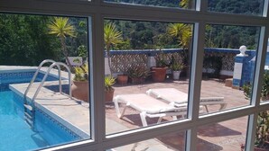 A pool with a view of a mountainous landscape through large windows.