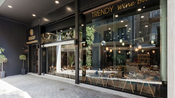 Un bar à vin au décor moderne, avec de grandes fenêtres et des places assises en plein air.