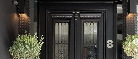 A black entrance door with a sign above stating "TRENDY by ATHENS PRIME HOTELS".