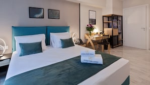 Une chambre d’hôtel avec un grand lit, un bureau avec une chaise, une armoire et un miroir.