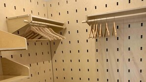 Ein begehbarer Kleiderschrank mit Holzregalen und Ablagefläche zum Aufhängen.