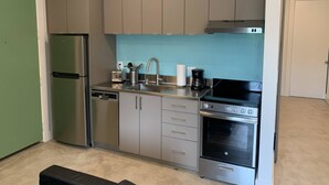 A compact kitchen with stainless steel appliances, a dishwasher, and a coffee maker. - Bardo Lofts Suite #204 (Dallas)