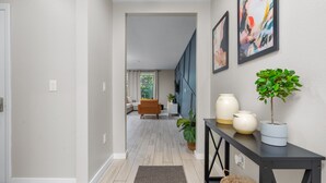 A hallway with a modern interior, a staircase, and a living area with a sofa and a coffee table. - Disney-Themed Escape – Frozen & Star Wars Rooms, Pool, Games & Family Fun (Kissimmee)