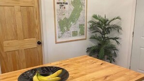 A kitchen with a wooden countertop, a bowl of bananas, a map on the wall, and a potted plant. - Heart and soul on Windrock (Oliver Springs)
