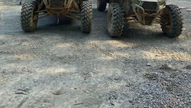 Two off-road vehicles parked in front of a two-story house with a porch. - Heart and soul on Windrock (Oliver Springs)