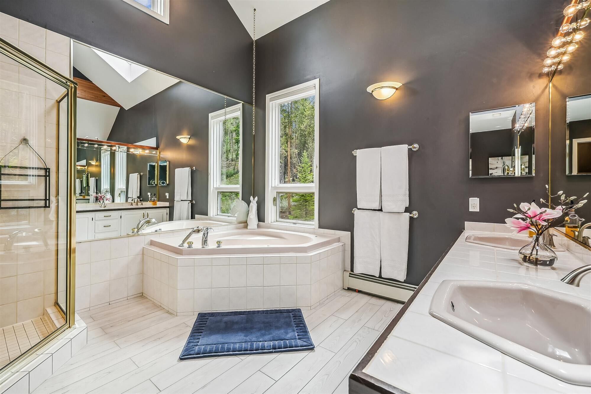 Une salle de bain moderne dotée d’une grande baignoire, de deux lavabos et d’une douche à l’italienne.