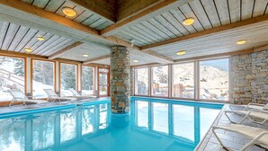 An indoor swimming pool with clear views of snowy mountains through large windows. - travelski home select - Résidence Aspen 4* - 3 pièces 6/7 personnes (La Plagne)
