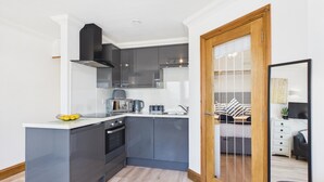A compact kitchen with modern appliances, a microwave, and a kettle. - Ocean View - 1 Bedroom Apartment - Saundersfoot (Saundersfoot)