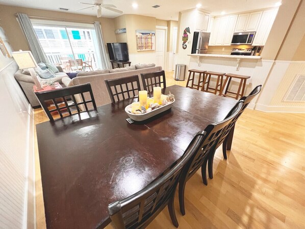 A dining area with a large wooden table, chairs, and a centerpiece.
