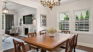 A dining room with a wooden table and chairs, a chandelier, and a fireplace. - EXPO Oasis-Heart of Tulsa! (Tulsa)