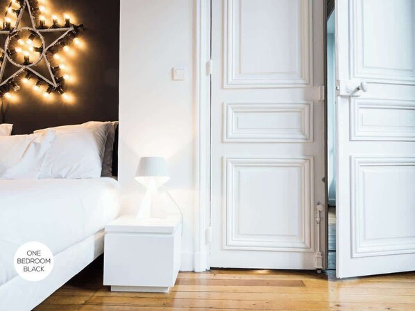 Un dormitorio con cama, mesita de noche, lámpara y una lámpara con forma de estrella.