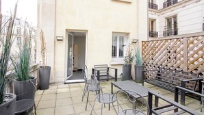 A courtyard with outdoor seating, potted plants, and a wooden lattice wall.