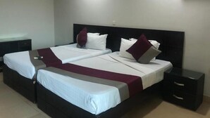 A double bed with white and maroon bedding, two nightstands, and a black headboard. - Korkdam Hotel (Accra)
