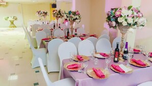 A banquet hall with round tables set for a formal event, each with white chairs and pink napkins. - Korkdam Hotel (Accra)