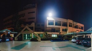 A hotel with a central building, a parking lot, and a smaller structure to the right. - Korkdam Hotel (Accra)