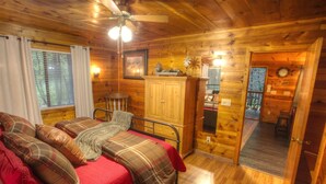 Une chambre confortable dans un chalet en bois, avec un lit, une armoire et un petit bureau.