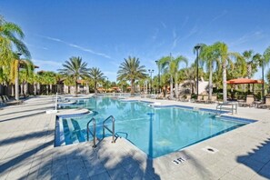 A large outdoor swimming pool surrounded by palm trees and lounge chairs. - 6 BR Villa w/Private Pool + Hot Tub + Lazy River in Gated Resort near Clubhouse (Davenport)