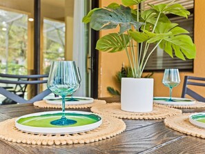 A table set with green glassware on a woven placemat, a potted plant, and a white vase. - 6 BR Villa w/Private Pool + Hot Tub + Lazy River in Gated Resort near Clubhouse (Davenport)