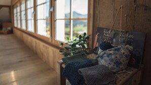 A room with large windows, wooden walls, and a bench with knitting materials. - NEW - renovated Bitzi - with a view (Appenzell)