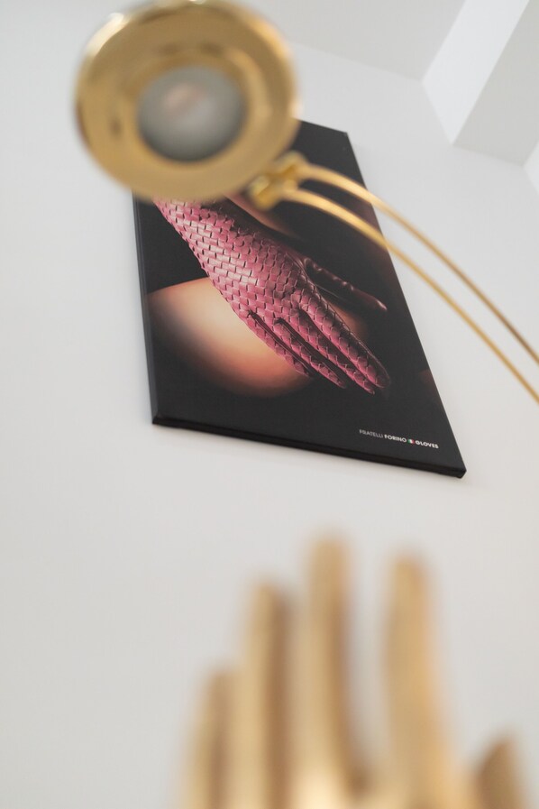 A pair of golden eyeglasses with a magnifying lens, resting on a white surface. - Astonishing Studio for 2 people in the Heart of Naples 3P (Napoli)