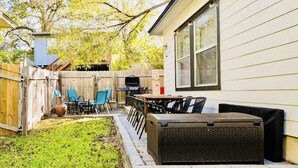 A backyard with a patio, outdoor seating, and a barbecue grill. - 5 mins to best of ATX, Stocked kitchen, 4BR 2.5BA, Backyard, Grill, yard games (Austin)