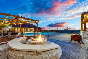 A poolside area with a fire pit, outdoor seating, and a pergola. - Texas Farmhouse on 10 Acres with  private Pool and Hot Tub Spa (Celina)