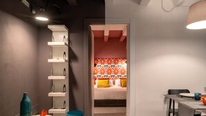 A modern room with a bed, a dining table, and a small seating area. - Apartment (Siracusa)