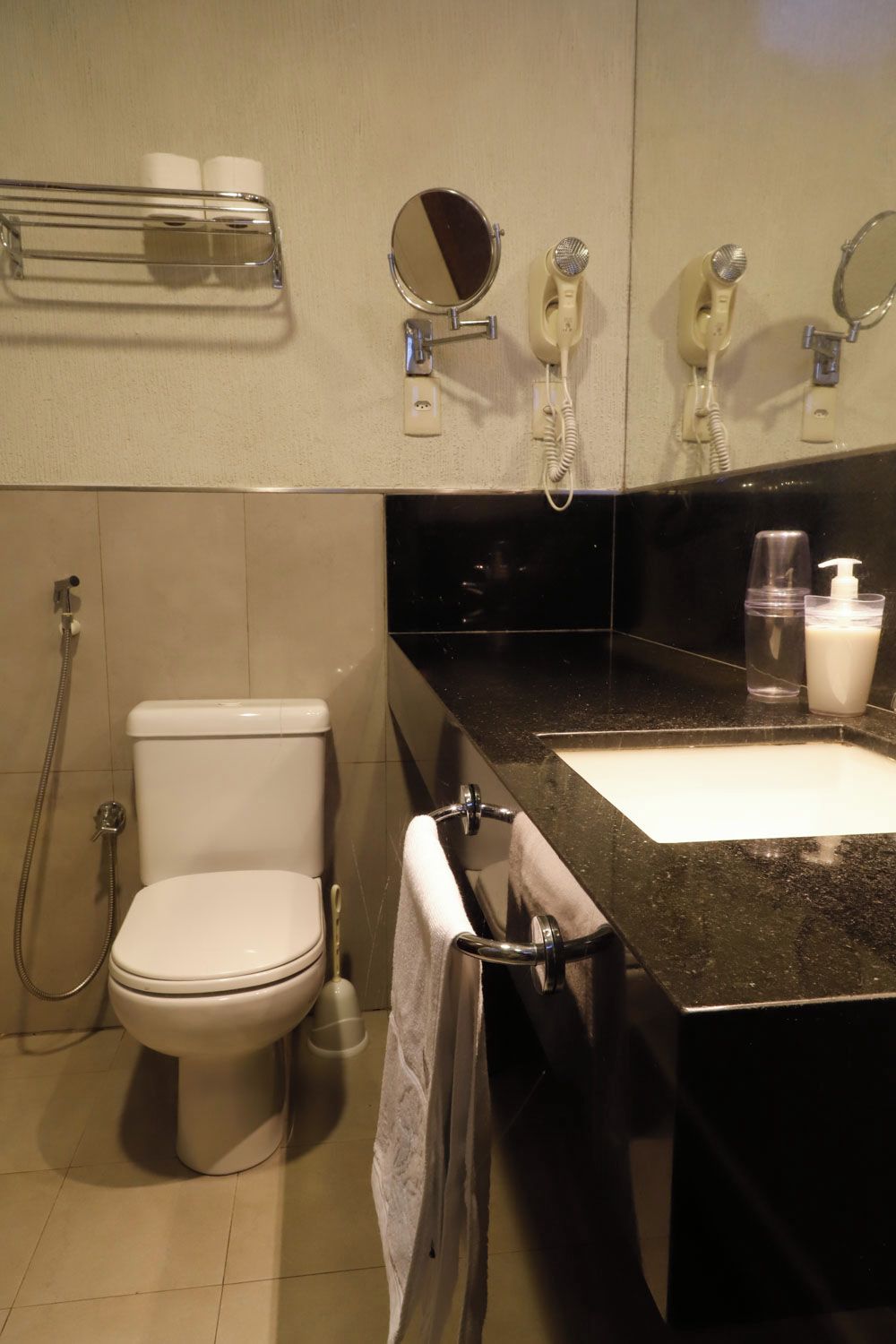 Un bagno con il water, un lavandino, uno specchio e una doccia.