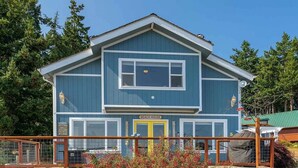 A two-story building with a blue exterior, a yellow door, and a sign that reads "BEACH HOUSE". - Amazing views (Sequim)
